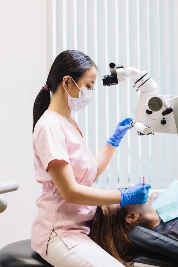 Medic care utilizează un microscop dentar în timpul tratamentului